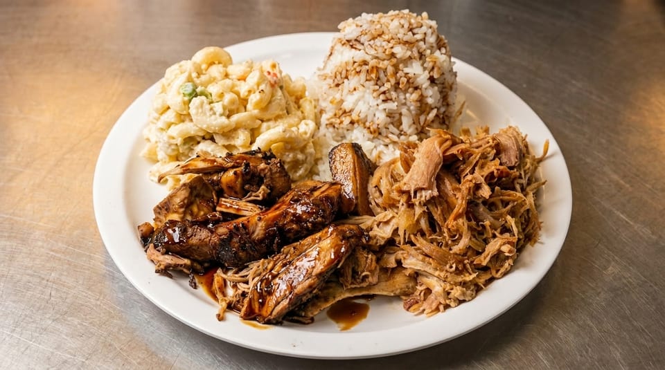 A plate of BBQ ribs, pulled pork, macaroni salad, and rice with sauce.